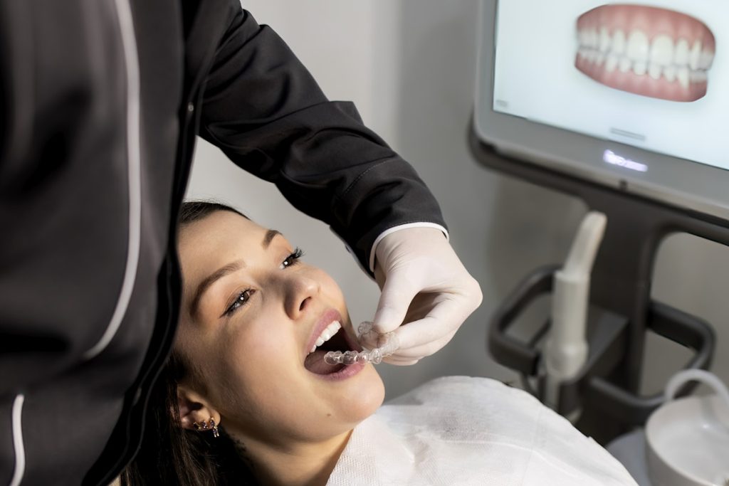 A dental professional examining a patient with an intraoral scanner in a treatment room